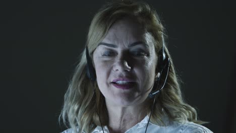 Smiling-businesswoman-in-headset-talking-at-camera